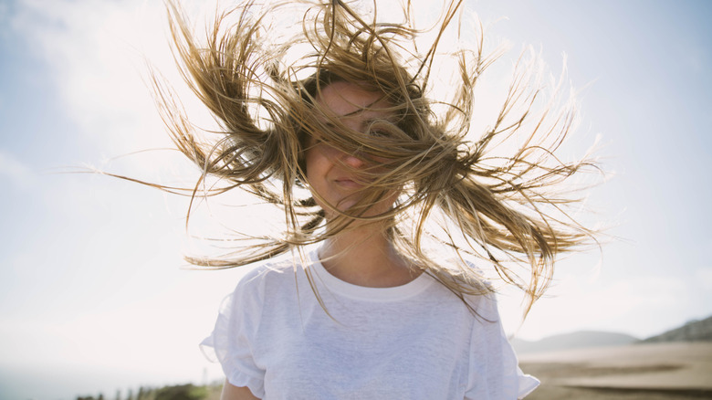 wind blows woman's hair