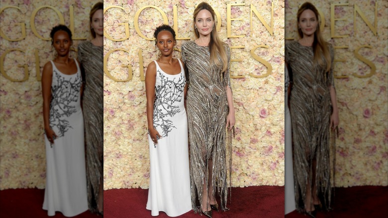 Zahara Jolie in a white dress with Angelina Jolie in a metallic dress on the red carpet