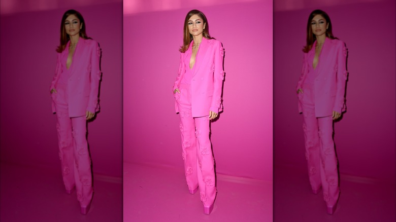 Zendaya posing against a pink background at Paris Fashion Week in 2022